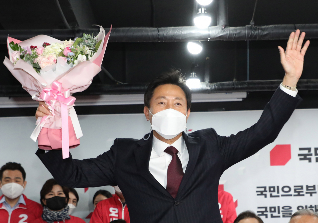 4·7 재보궐 선거에서 서울시장 당선이 확실해진 국민의힘 오세훈 후보가 8일 자정께 서울 여의도 당사 개표상황실에서 꽃다발을 받고 기뻐하고 있다. [연합]