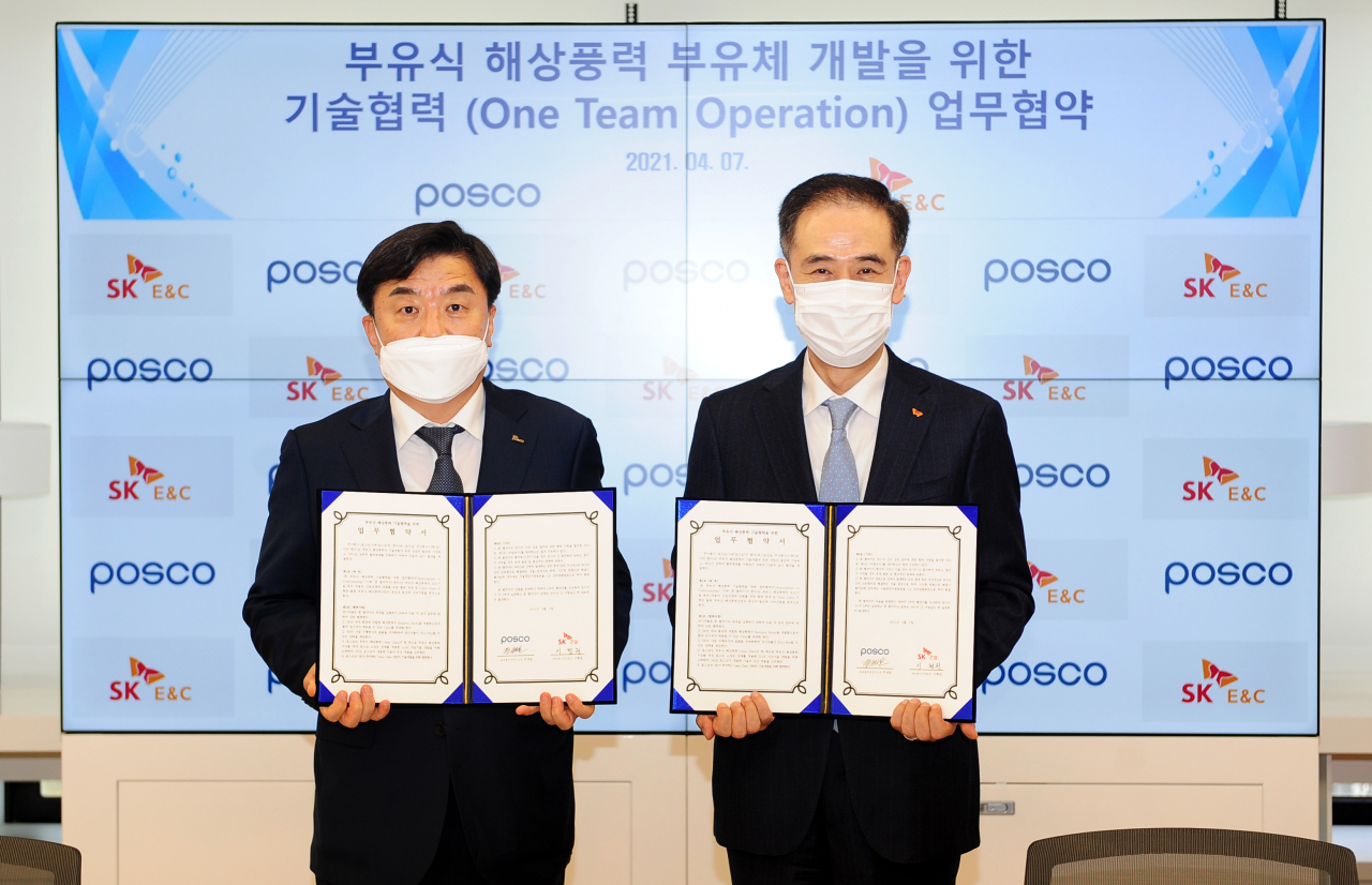이형원 SK건설 에코에너지부문장(오른쪽)과 주세돈 포스코 철강솔루션연구소장이 협약서를 들고 기념촬영을 하고 있는 모습. [SK건설 제공]