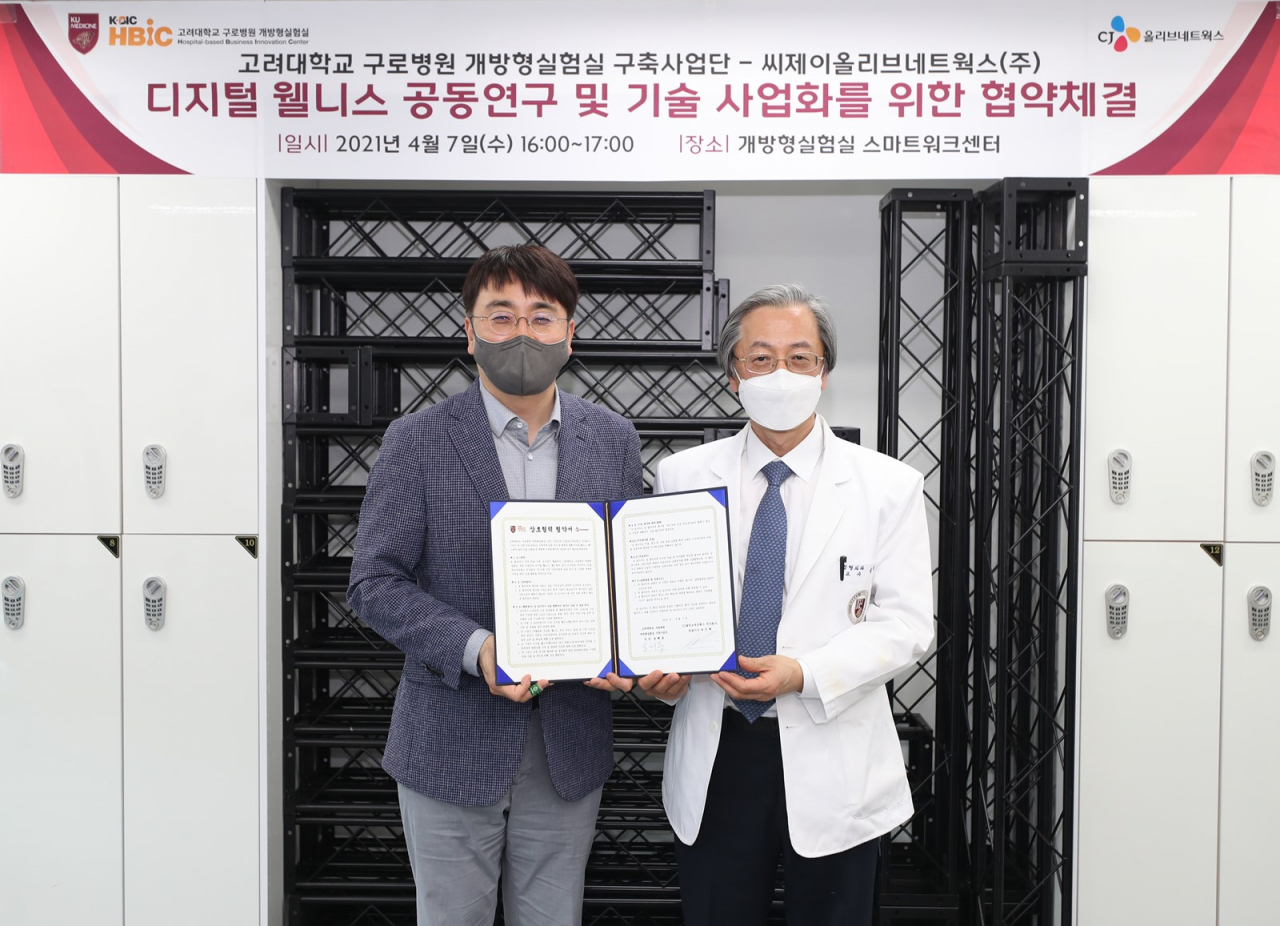 고대구로빌딩 개방형실험실 스마트워크센터에서 CJ올리브네트웍스 차인혁 대표(왼쪽)와 고려대구로병원 개방형실험실 구축사업단 송해룡 단장이 디지털 웰니스 공동연구 및 기술 사업화를 위한 협약을 체결하고 기념사진을 촬영하고 있다. [CJ올리브네트웍스 제공]