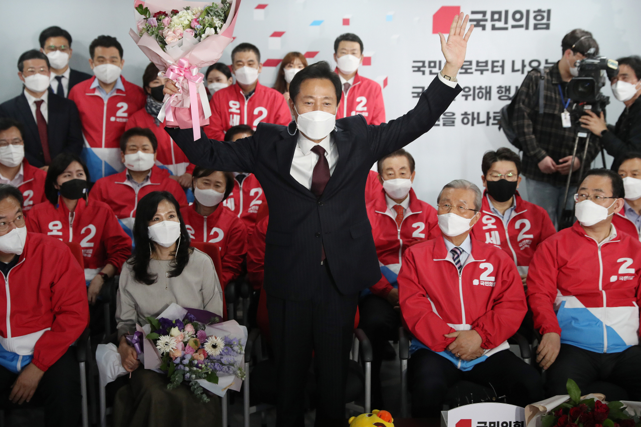 4·7 재보궐 선거에서 서울시장 당선이 확실해진 국민의힘 오세훈 후보가 8일 자정께 서울 여의도 당사 개표상황실에서 꽃다발을 받고 기뻐하고 있다. [연합]