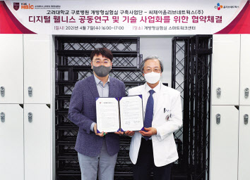 고대구로빌딩 개방형실험실 스마트워크센터에서 CJ올리브네트웍스 차인혁(왼쪽) 대표와 고려대구로병원 개방형실험실 구축사업단 송해룡 단장이 디지털 웰니스 공동연구 및 기술 사업화를 위한 협약을 체결하고 기념사진을 촬영하고 있다. [CJ올리브네트웍스 제공]