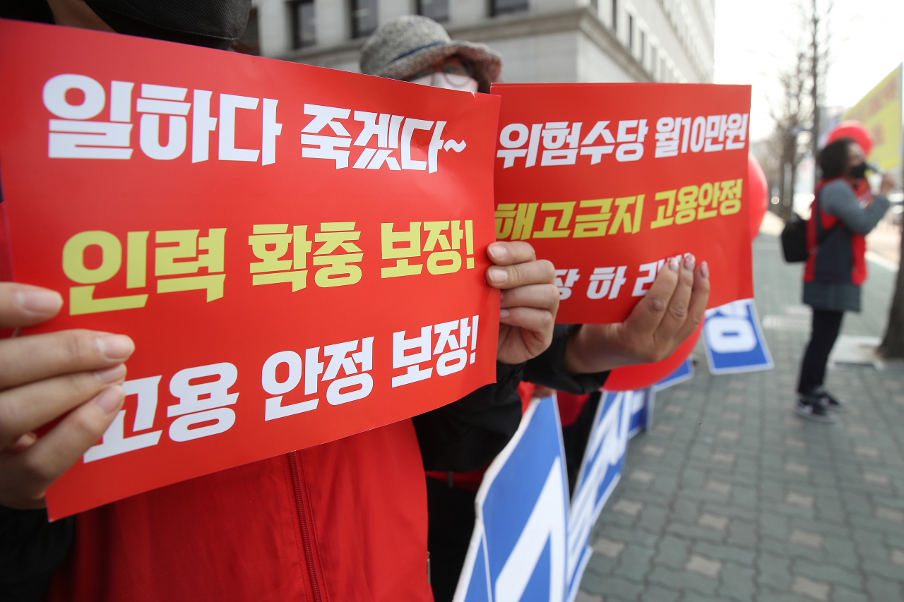 ‘3.25 요양노동자 하루멈춤 집단행동’이 진행된 25일 오후 서울 여의도 국회 정문 횡단보도에서 요양보호사들이 손팻말을 들고 있다. [연합]