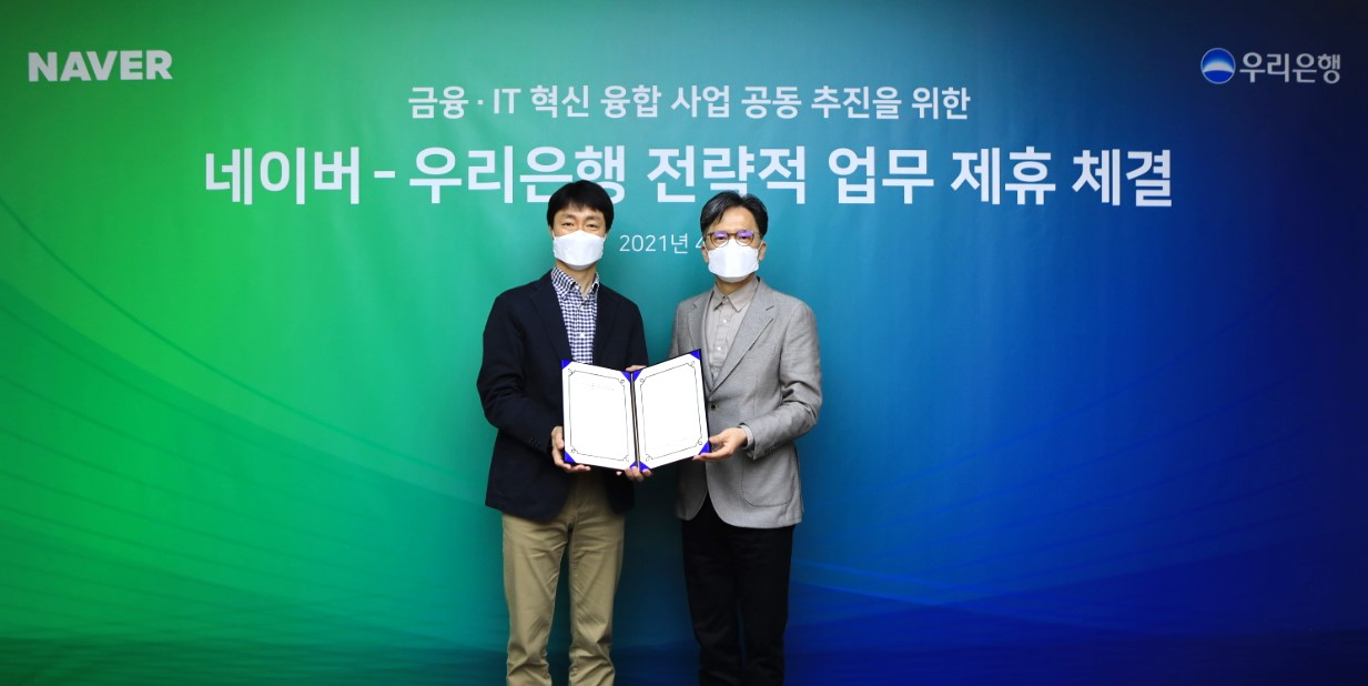 황원철(오른쪽) 우리은행 DT추진단장이 유봉석 네이버 서비스 운영총괄과 기념촬영을 하고 있다.