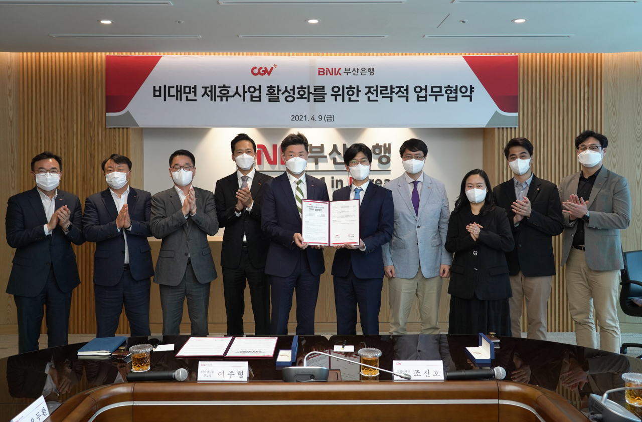 BNK부산은행은 9일 본점에서 CJ CGV㈜와 ‘비대면 제휴사업’ 활성화를 위한 전략적 업무협약을 체결했다. 사진 중앙 왼쪽 부산은행 이주형 디지털금융본부장, 오른쪽 CJ CGV㈜ 조진호 마케팅 영업담당. [부산은행 제공]