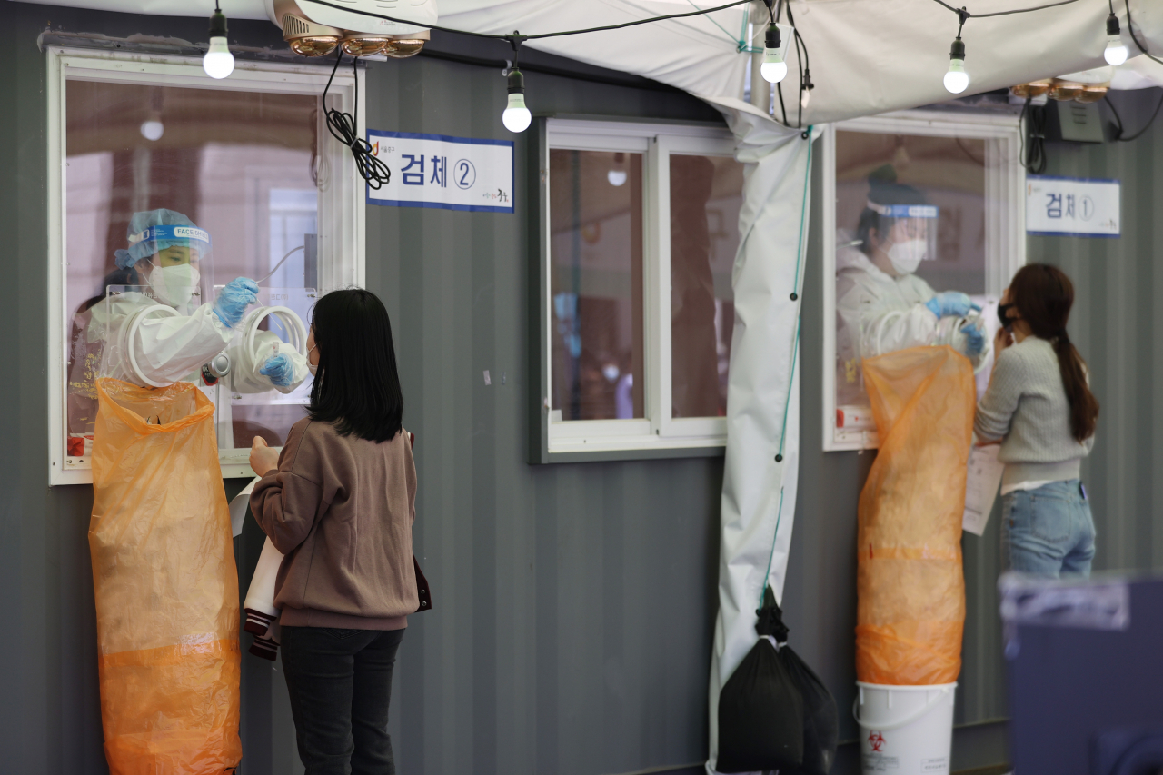 신종 코로나바이러스 감염증(코로나19) 신규 확진자가 671명 발생한 지난 9일 오전 서울역광장에 마련된 임시선별진료소에서 의료진이 검체채취를 하고 있다. [연합]