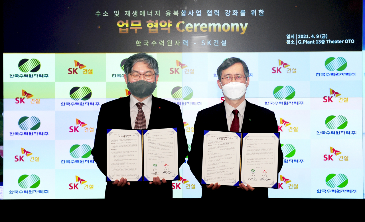 안재현 SK건설 사장(왼쪽)과 정재훈 한국수력원자력 사장이 협약서를 들고 기념촬영을 하고 있는 모습.[SK건설 제공]