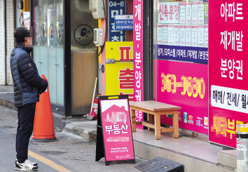 서울 서대문구의 한 부동산 사무실 앞에서 한 시민이 인근 아파트들의 매매와 전세, 월세 가격을 살펴보고 있다. [연합]