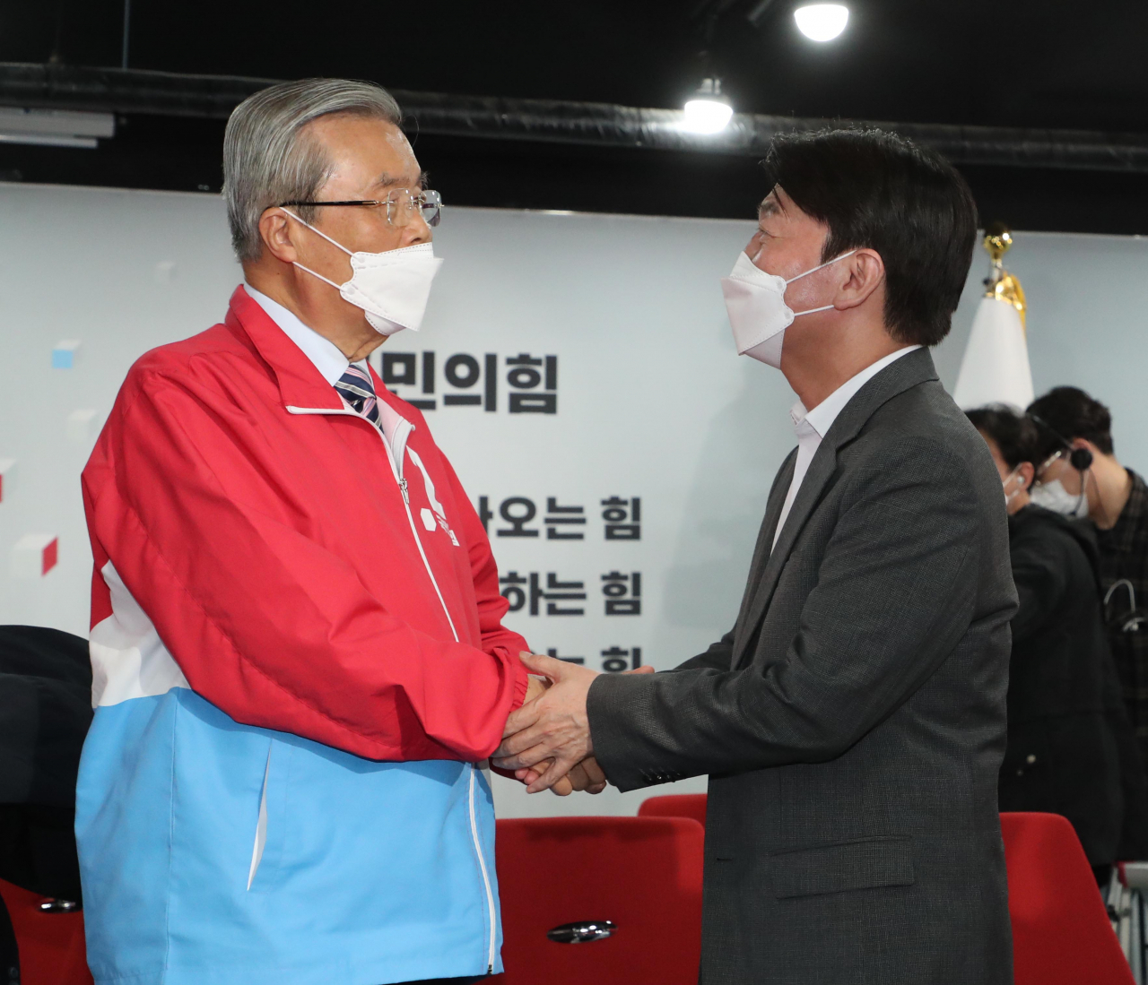 4·7 재보궐 선거에서 국민의힘 오세훈 서울시장 후보의 당선이 확실해진 8일 자정께 서울 여의도 당사 국민의힘 개표상황실에서 김종인 비상대책위원장(왼쪽)과 국민의당 안철수 대표가 손을 맞잡고 있다. [연합]