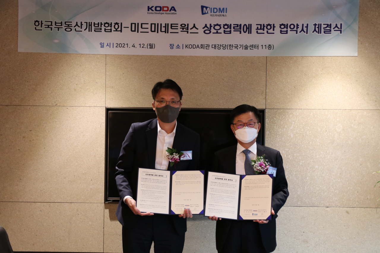 한국부동산개발협회 김승배 회장(오른쪽)과 미드미네트웍스 이월무 대표가 12일 협약서에 사인한 후 포즈를 취하고 있다. [한국부동산개발협회 제공]