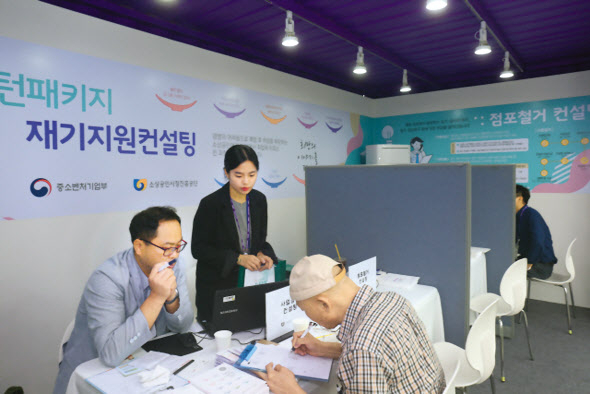 1인 자영업자들이 코로나19발 경기침체의 직겨탄을 맞고 있다. 지난해 서울 광화문광장에서 열린 실패박람회에서 소상공인시장진흥공단 직원이 부스 방문자에게 고용보험료 지원제도에 대해 설명하고 있는 모습. [헤럴드DB]