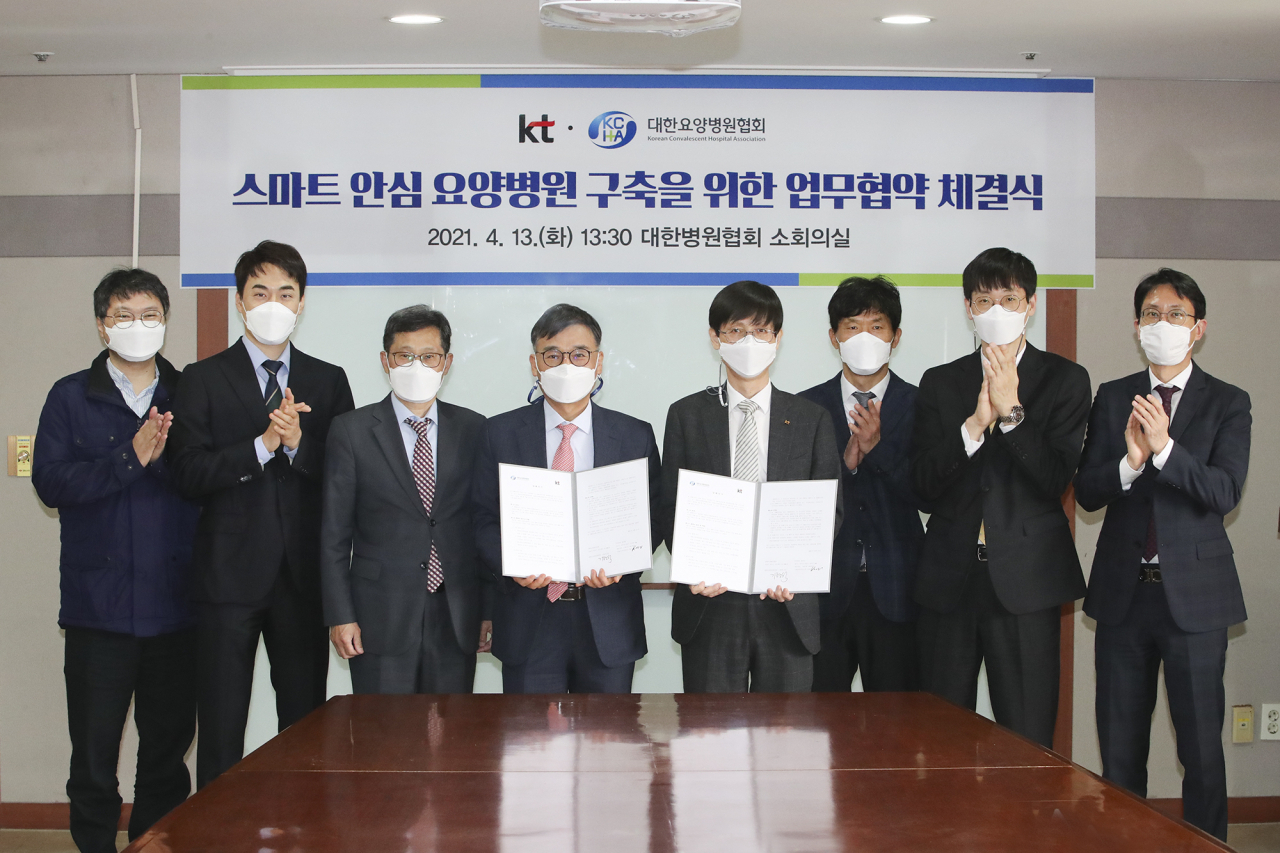 KT와 대한요양병원협회는 13일 서울시 마포구에 위치한 대한요양병원협회에서 ‘디지털헬스 패스’와 ‘스마트안심 요양병원 케어 서비스’ 구축을 위한 업무협약(MOU)을 체결했다고 밝혔다. 업무협약식에 참석한 (왼쪽부터 네번째)기평석 대한요양병원협회장, (오른쪽부터 네번째)김형욱 KT 미래가치추진실장 부사장을 비롯한 양측 임원들과 관계자들이 기념사진 촬영에 임하고 있는 모습 [KT 제공]