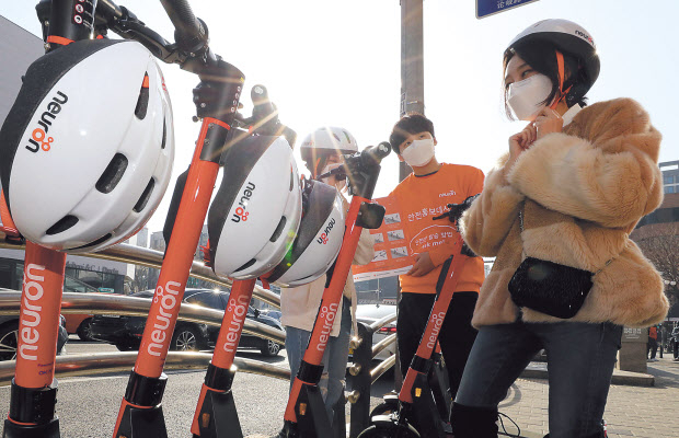 지난 3월 5일 오전 서울 강남구 학동역 인근에서 전동킥보드 이용자들이 이날 서비스를 시작한 안전 기능을 대폭 강화한 ‘뉴런 전동킥보드’를 타기에 앞서 안전 헬멧을 쓰고 있다.(사진은 기사 내용과 관련없음) [연합]