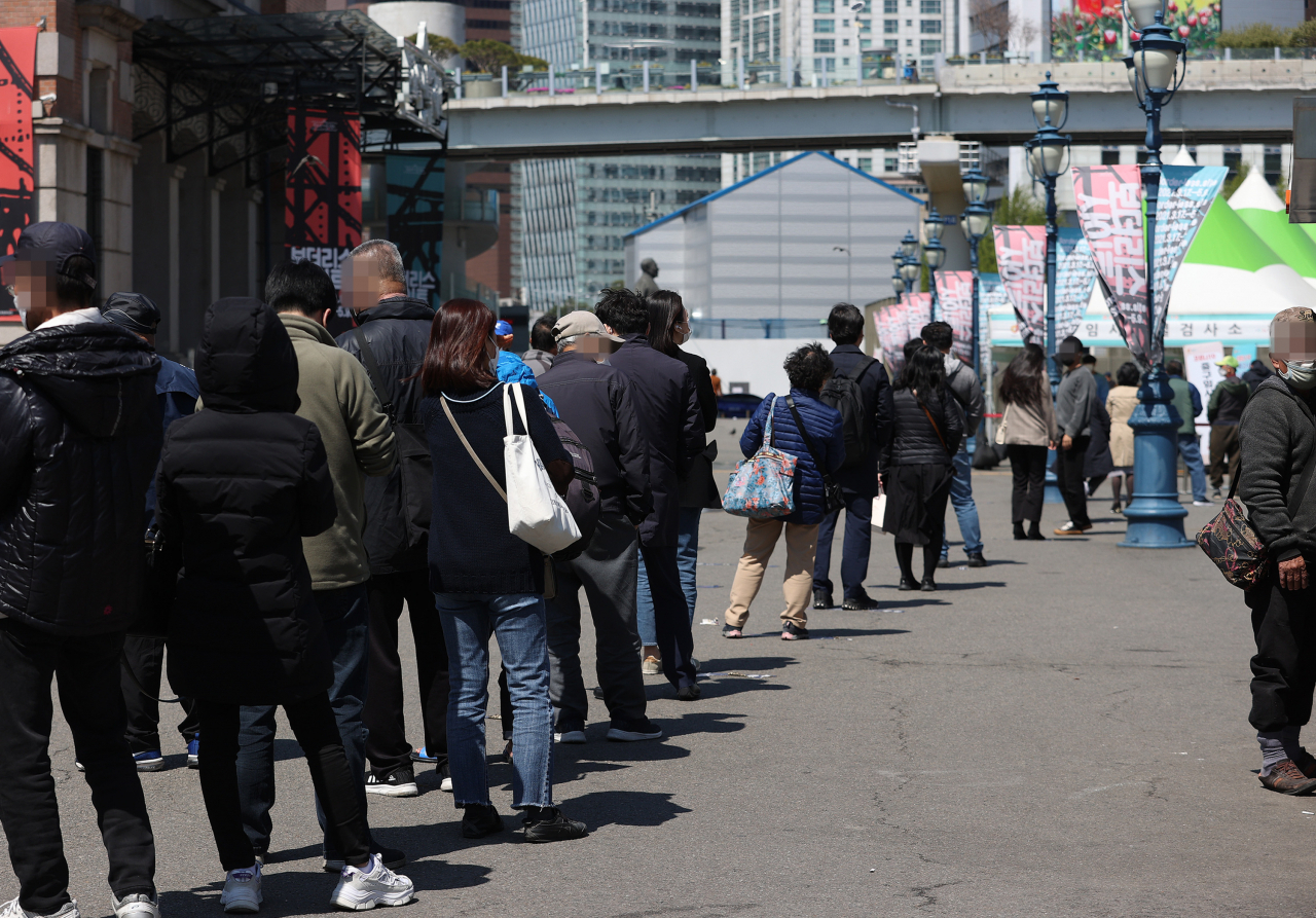 14일 오후 서울역광장에 마련된 임시선별진료소에서 시민들이 검사를 받기 위해 줄을 서고 있다. [연합]
