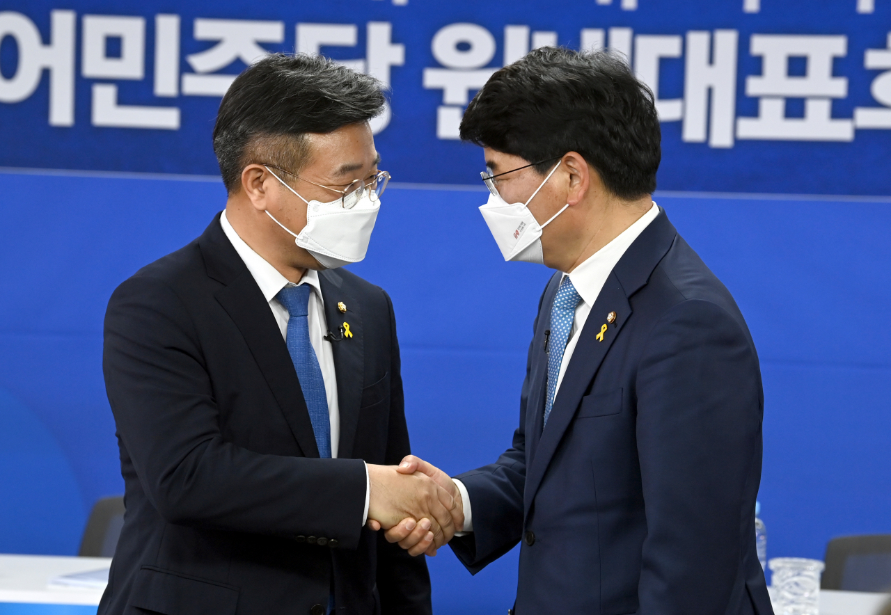 더불어민주당 원내대표 경선에 출마한 윤호중 의원(왼쪽)과 박완주 의원이 15일 서울 여의도 중앙당사에서 열린 합동토론회에서 악수하고 있다. 이상섭 기자