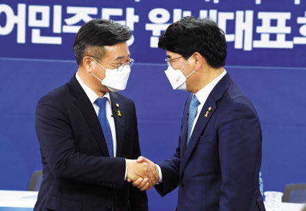 더불어민주당 원내대표 경선에 출마한 윤호중 의원(왼쪽)과 박완주 의원이 15일 서울 여의도 중앙당사에서 열린 합동토론회에서 악수하고 있다.[국회사진기자단]