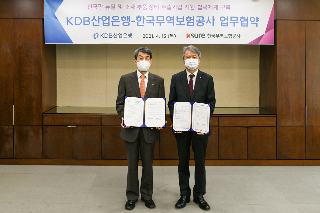 이인호(오른쪽) 한국무역보험공사 사장이 15일 서울 종로구 본사에서 한국산업은행과 한국판 뉴딜 및 소재·부품·장비 기업의 해외 진출을 지원하기 위한 업무협약을 체결한 후 기념촬영을 하고 있다.