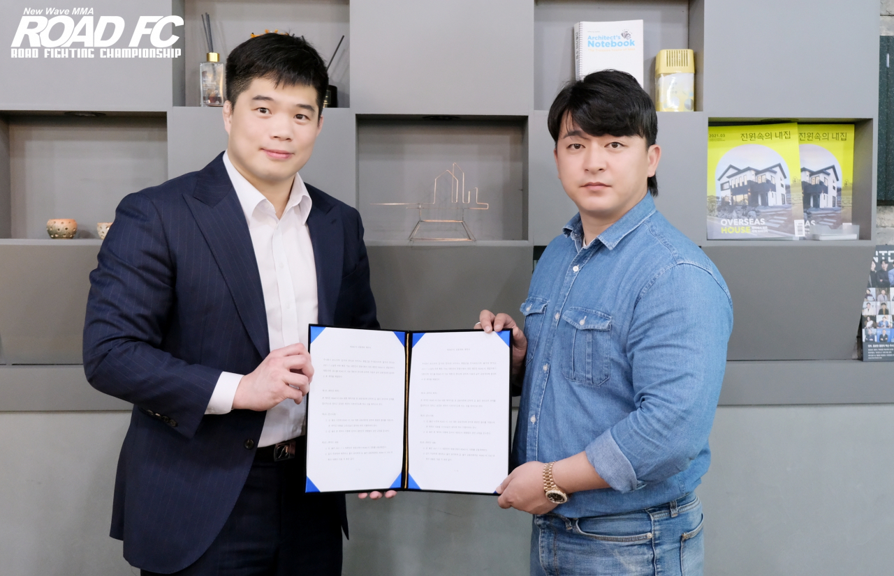 로드FC 김대환 대표가 박준혁 ㈜아키우노 종합건설 대표와 공동개최 계약서를 들어보이고 있다. [로드FC 제공]