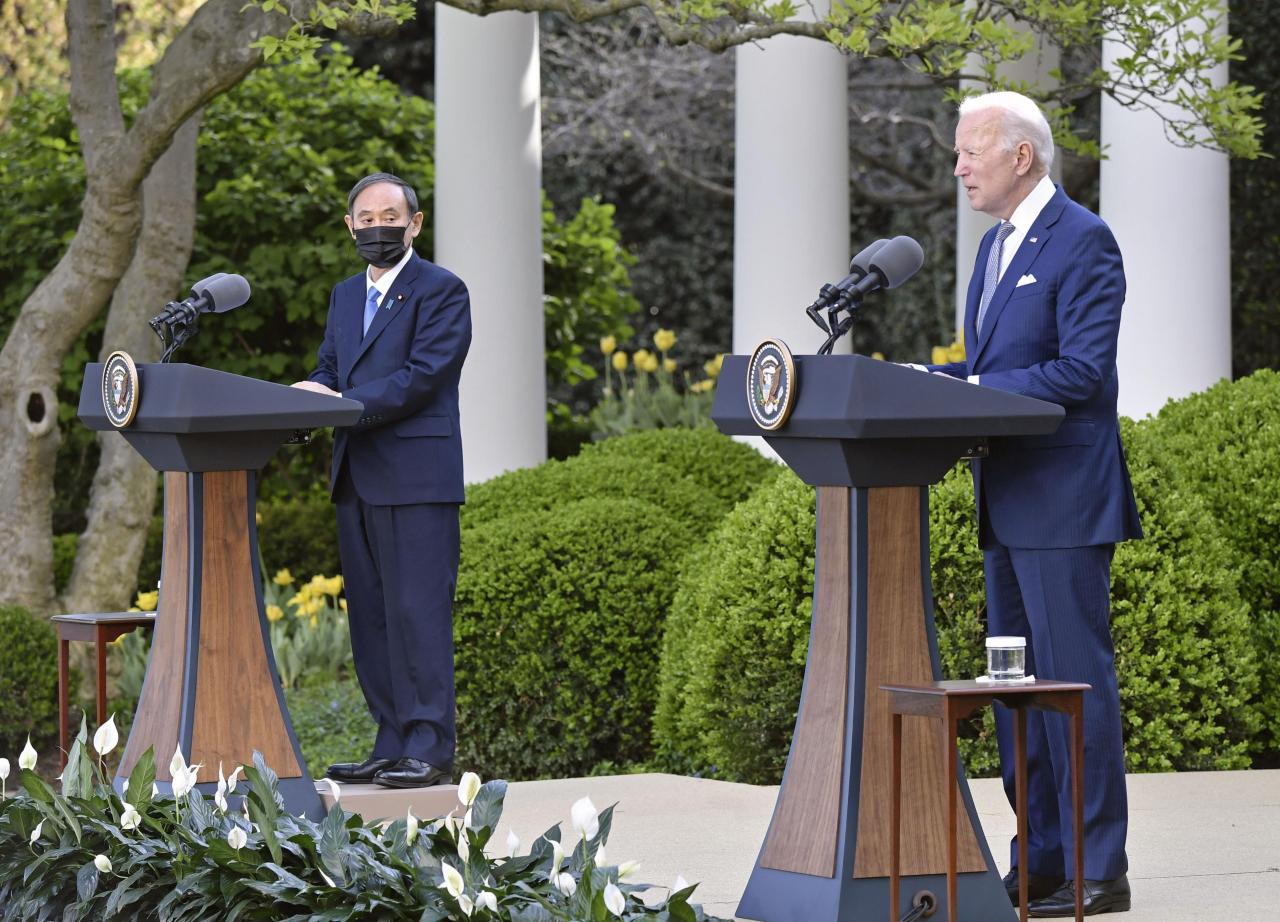 US President Joe Biden (right) and Japanese Prime Minister Yoshihide Suga (left) hold a joint press conference Friday after holding a bilateral summit in Washington. (Yonhap)