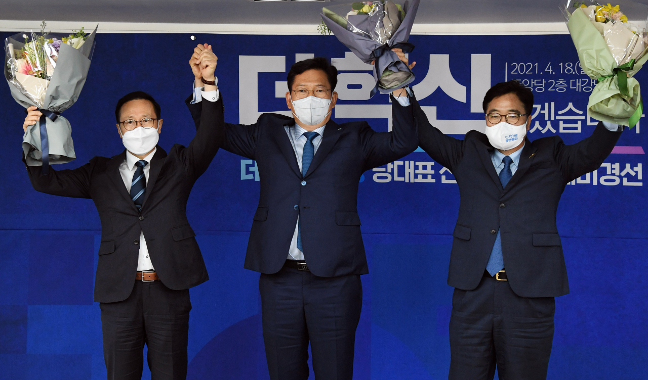 18일 서울 영등포구 더불어민주당 중앙당사 대강당에서 열린 더불어민주당 당대표 선출을 위한 예비경선대회에서 당대표 후보로 선출된 홍영표(왼쪽부터), 송영길, 우원식 후보가 손을 맞잡아 들고 기념촬영을 하고 있다. [국회사진기자단]
