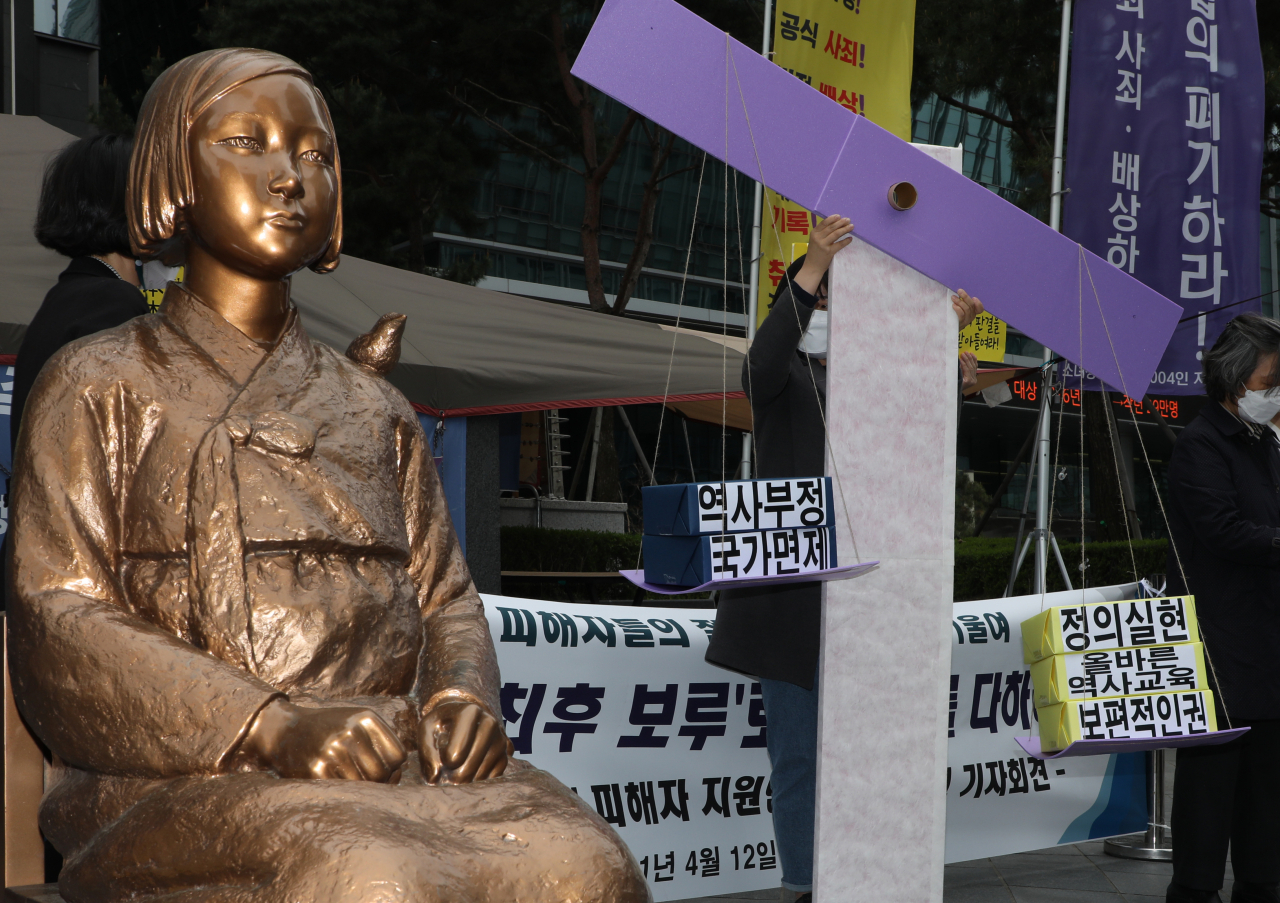 일본군 위안부 피해자 지원단체 관계자들이 지난 12일 서울 종로구 옛 일본대사관 앞에서 정의로운 손해배상청구소송 판결을 요구하는 퍼포먼스를 하고 있다. ‘일본군성노예제문제해결을 위한 정의기억연대’ 등이 참여했다. [연합]