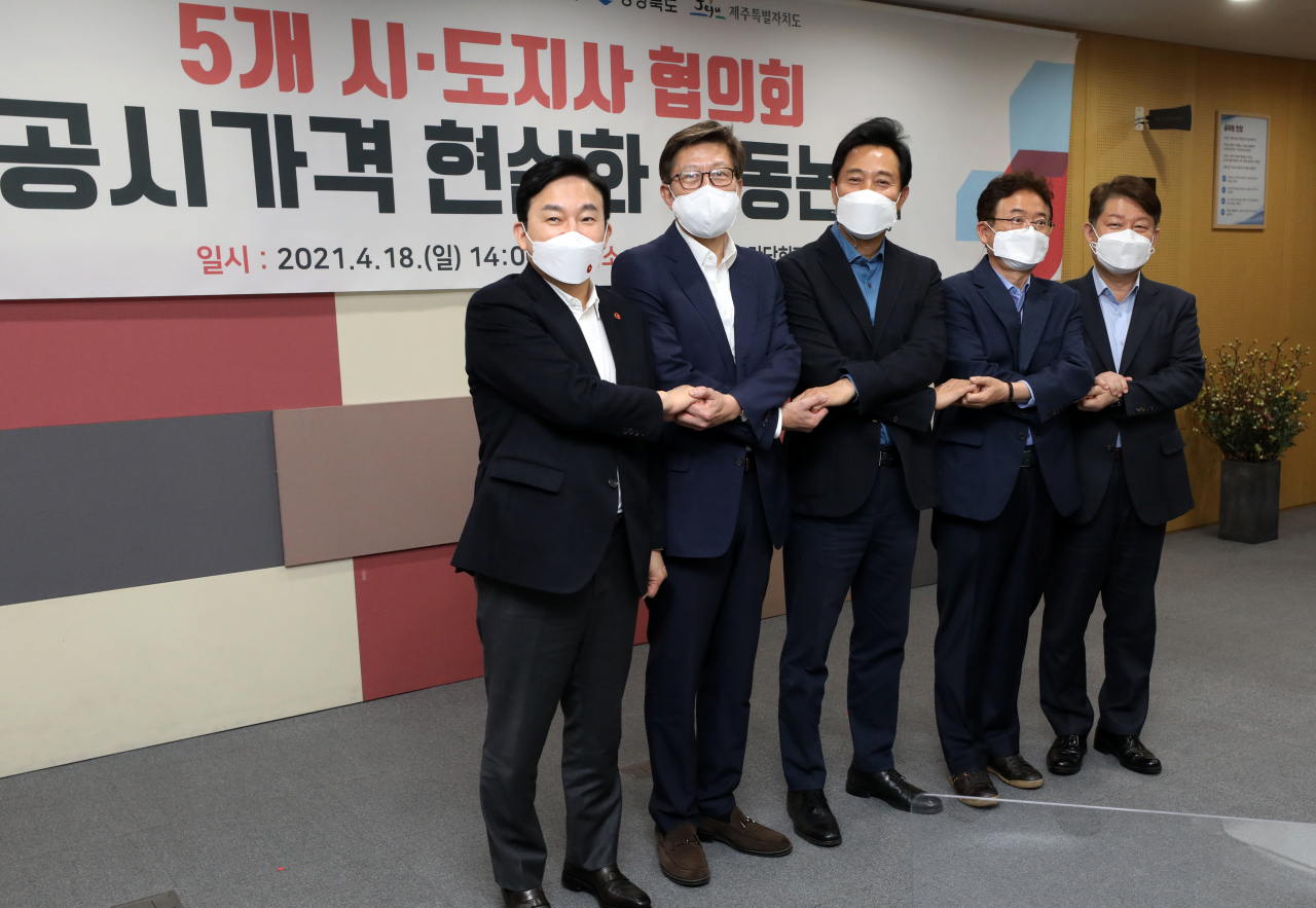 18일 오후 서울시 중구 서울시청에서 열린 공시가격 현실화 공동논의를 위한 국민의힘 소속 5개 시·도지사 협의회에서 참석자들이 손을 모아 악수하고 있다. [연합]