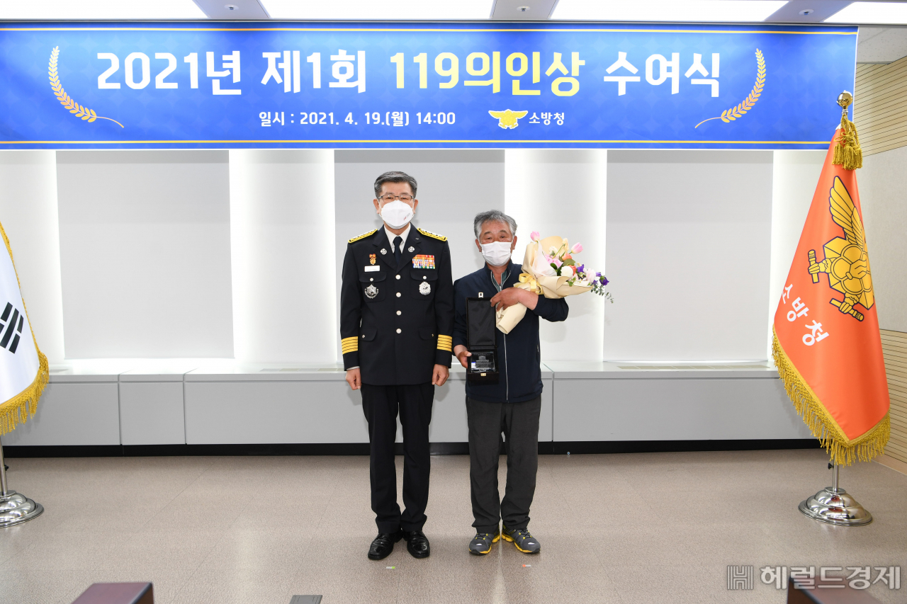 19일 열린 119의인상 수여식에서 신열우(왼쪽) 소방청장과 119의인상을 받은 김기문씨가 기념 촬영을 하고 있다. [소방청 제공]