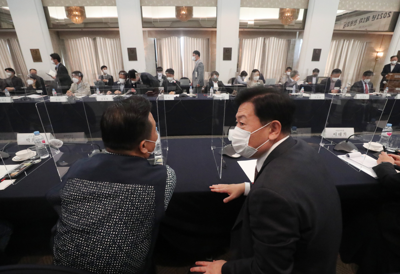 20일 오후 서울 중구 한국프레스센터에서 열린 최저임금위원회 1차 전원회의에서 이동호 근로자위원(왼쪽)과 류기정 사용자위원이 대화하고 있다. [연합]