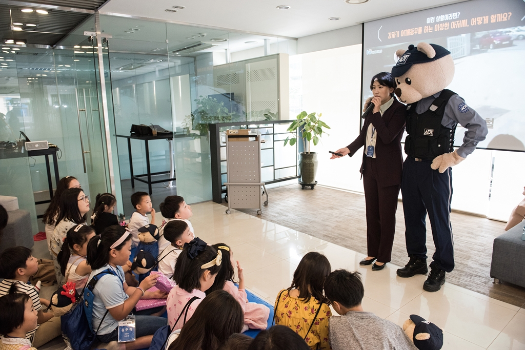 ADT캡스 직원이 친근감을 주는 모습으로 어린이들에게 교통안전에 대한 교육을 하고 있다.[ADT캡스 제공]