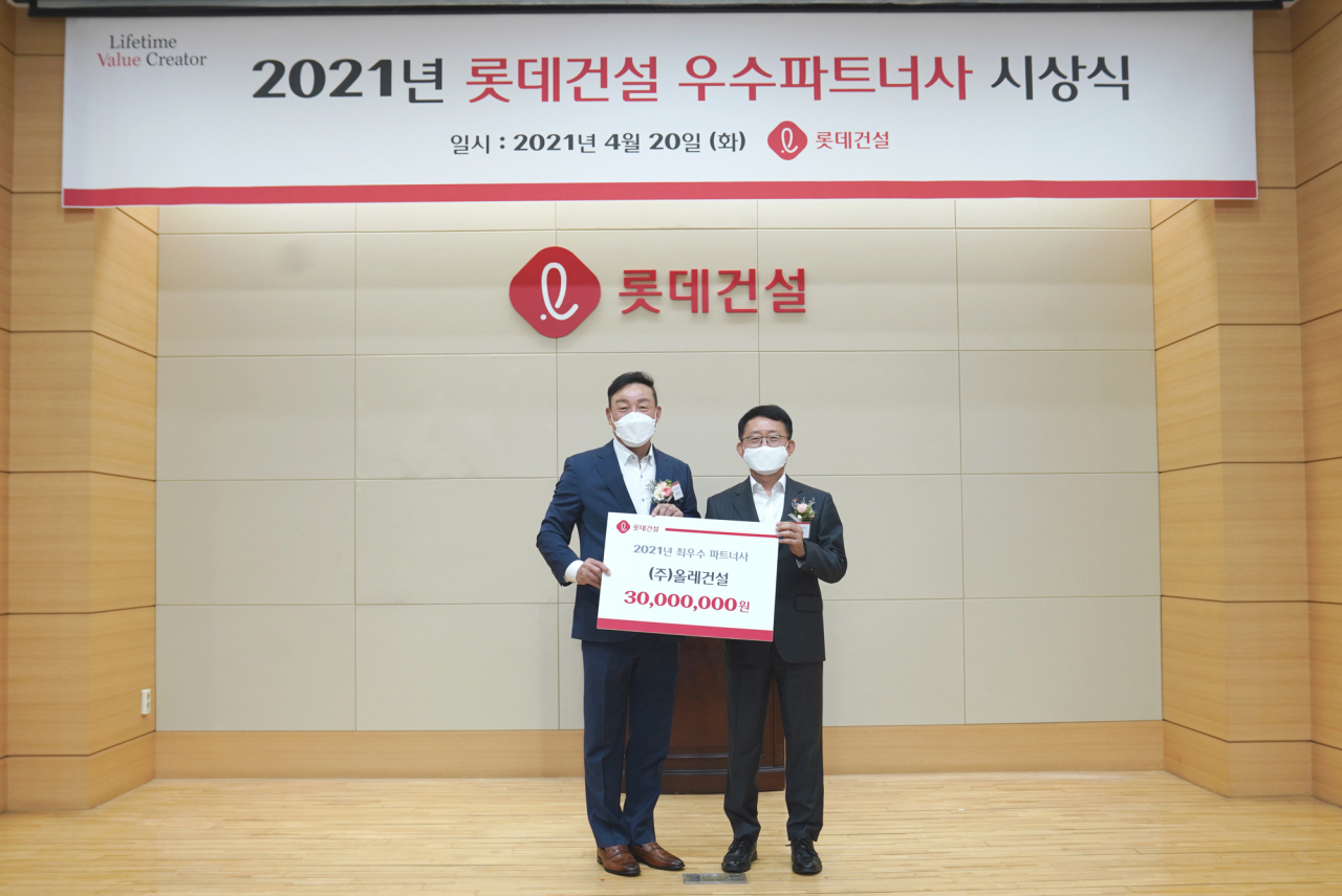 롯데건설 하석주 대표(우측)와 최우수 파트너사로 선정된 ㈜올레건설 최영복 대표가 기념 촬영을 진행했다.[롯데건설 제공]
