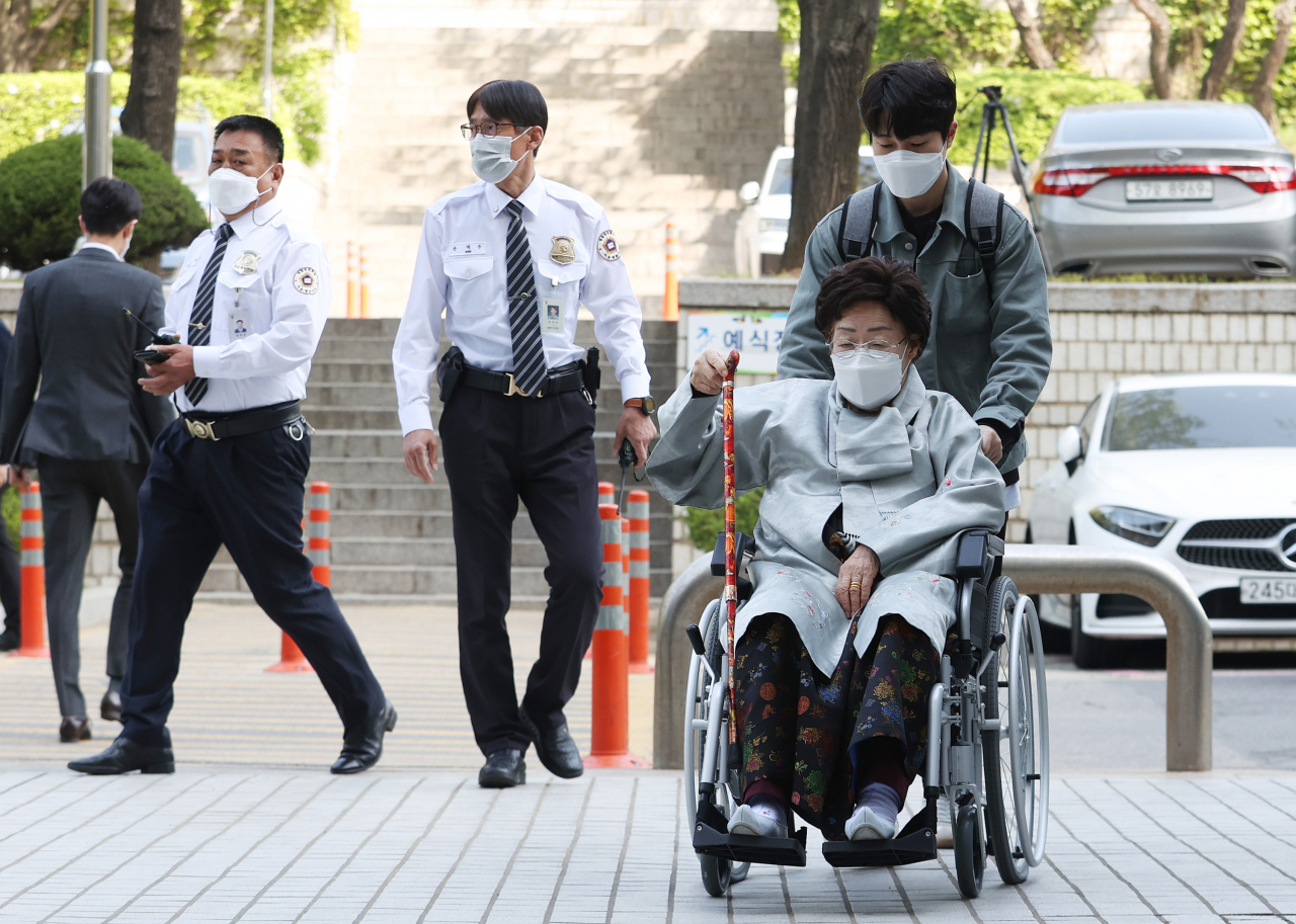 일본군 '위안부' 피해자들이 일본 정부를 상대로 제기한 두 번째 손해배상 소송 선고공판이 열린 21일 오전 서울 서초구 서울중앙지법에서 이용수 할머니가 법정으로 향하고 있다. [연합]