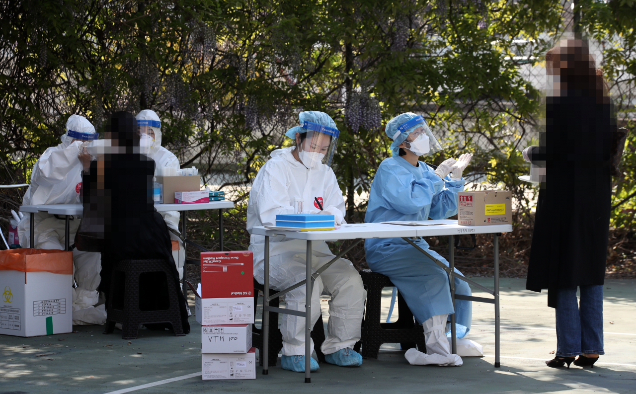 21일 오전 광주 남구 임시 선별검사소에서 시민들이 코로나19 검사를 받고 있다. [연합]