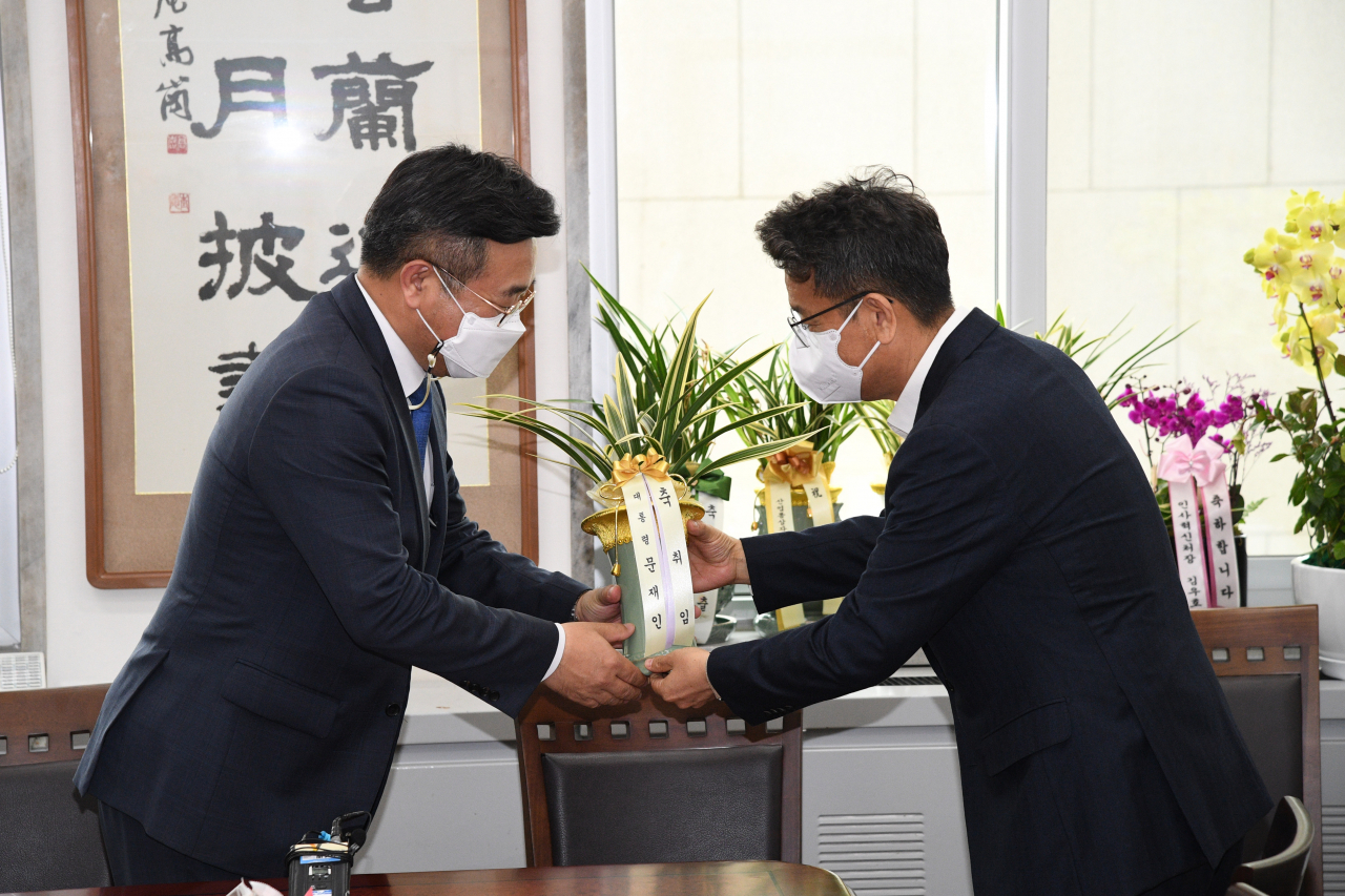 윤호중 더불어민주당 비상대책위원장 겸 원내대표(왼쪽)가 21일 서울 여의도 국회에서 이철희 청와대 정무수석으로 부터 문재인 대통령의 축하난을 전달받고 있다. 이상섭 기자