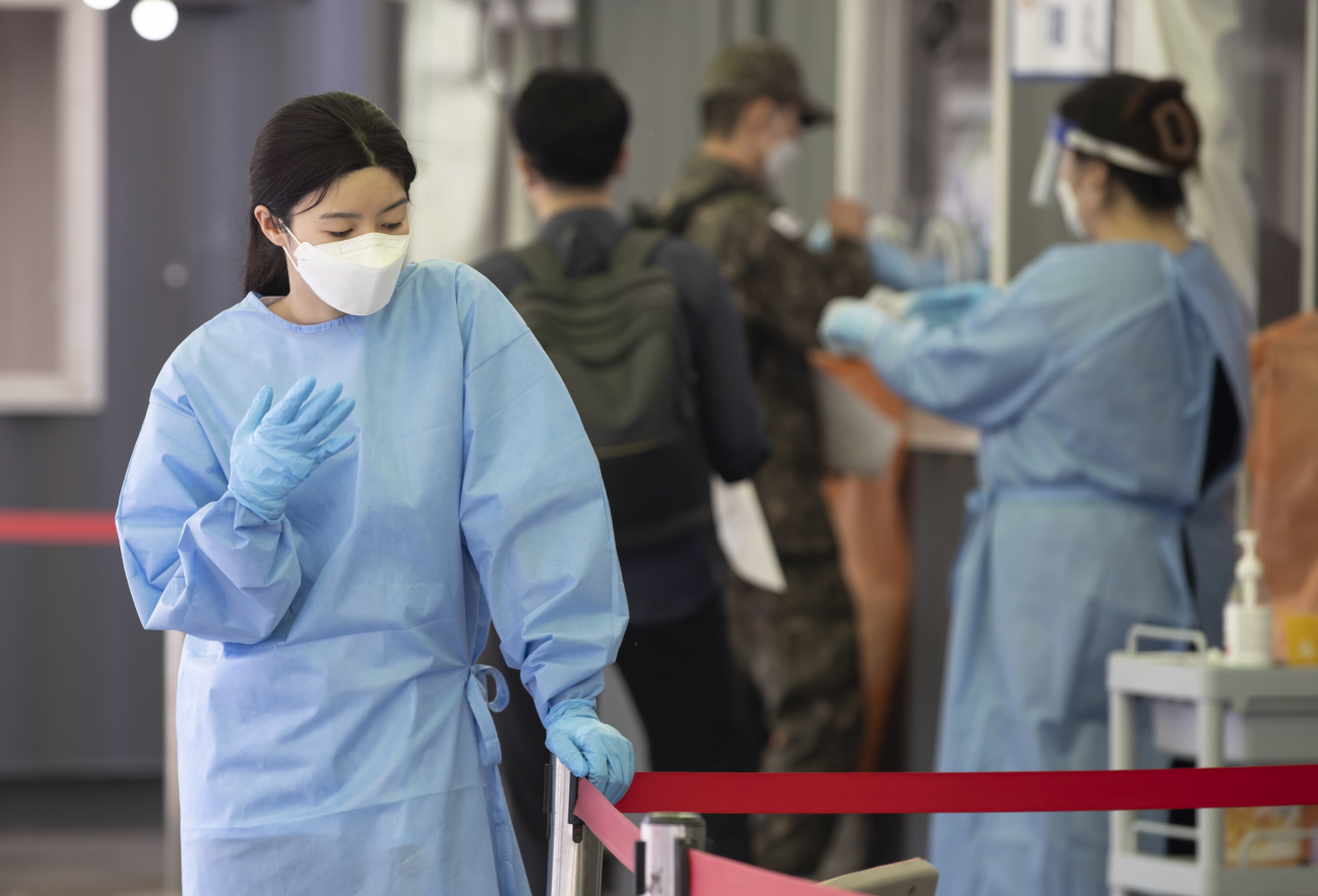신규 확진자 수가 또다시 700명대로 급증한 21일 오후 서울역 코로나19 임시선별검사소에서 한 관계자가 잠시 휴식을 취하고 있다. [연합]