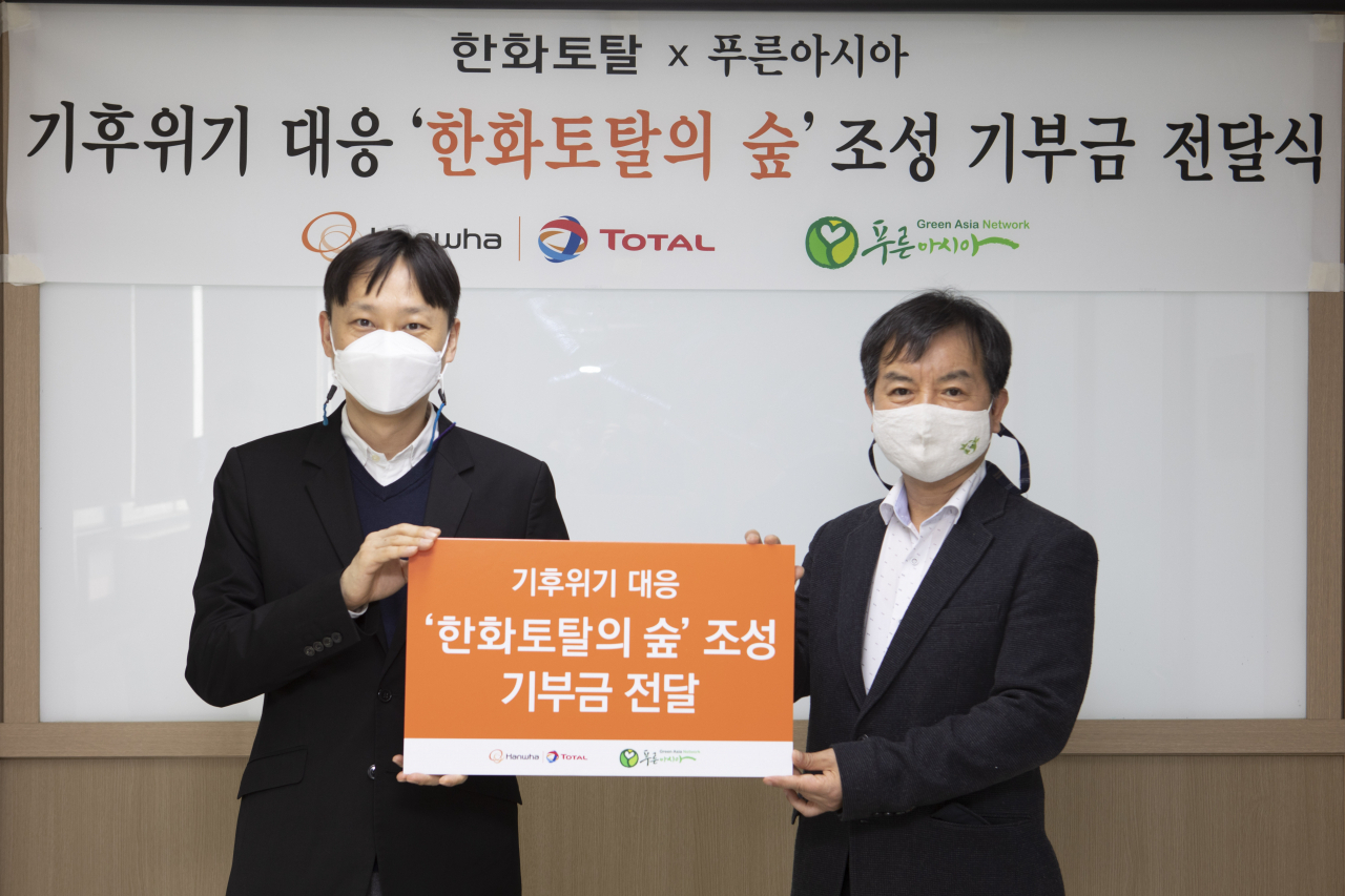 한화토탈은 22일 지구의 날을 맞아 기후변화로 사막화가 진행되고 있는 지역에 숲을 조성하기 위한 기금을 전달했다. 사진은 한화토탈 전지환 커뮤니케이션팀장(왼쪽)이 오기출 사단법인 푸른아시아 상임이사에게 기부금을 전달하는 모습. [한화토탈 제공]