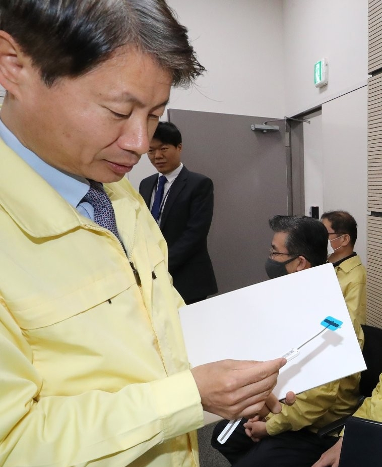 김강립 당시 중앙재난안전대책본부(중대본) 제1총괄조정관(보건복지부 차관)이 지난해 4월 24일 오전 세종시 정부세종청사에서 열린 코로나19 대응 중대본 정례 브리핑에 참석하며 ‘자가격리 위반자 안심밴드’를 살펴보고 있다. [연합]