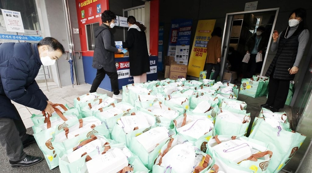 지난 1월 29일 오후 광주 북구청 복지누리동 앞 물품보관창고에서 구청 직원들이 코로나19 자가격리자 대상자들에게 전달할 생필품과 손소독제, 체온계, 마스크 등이 담긴 방역 키트를 옮기고 있다. [광주 북구 제공]