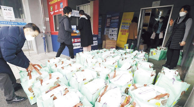 지난 1월 29일 오후 광주 북구청 복지누리동 앞 물품보관창고에서 구청 직원들이 코로나19 자가격리자 대상자들에게 전달할 생필품과 손소독제, 체온계, 마스크 등이 담긴 방역 키트를 옮기고 있다. [광주 북구 제공]