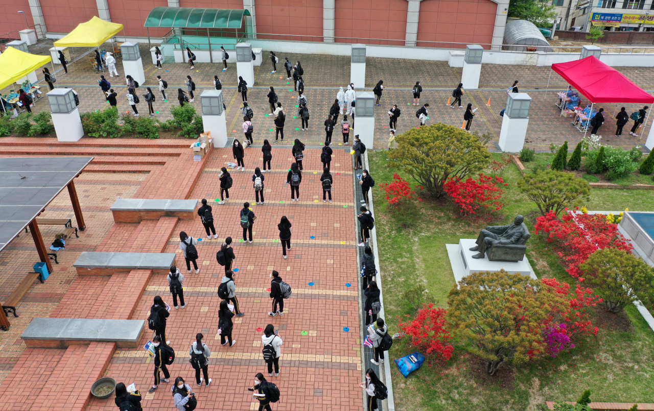 22일 오후 광주 북구 한 고등학교에 설치된 임시 선별진료소에서 학생들이 코로나19 검사를 받기 위해 줄 서 있다. [연합]