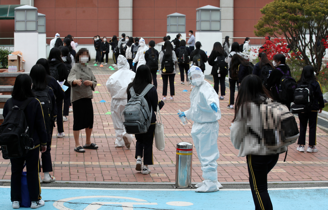 22일 오후 광주 북구 한 고등학교에 설치된 임시 선별진료소에서 학생들이 코로나19 검사를 받기 위해 줄 서 있다. [연합]