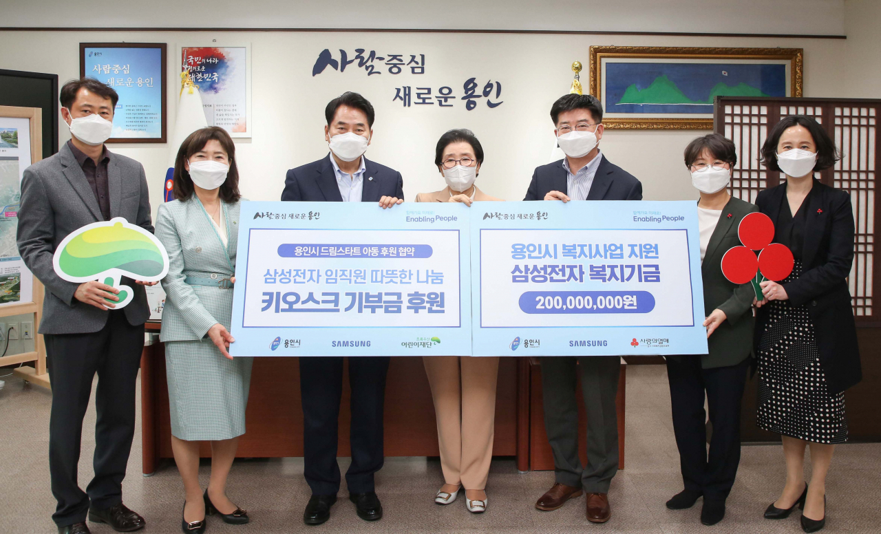 백군기 용인시장이 22일 용인시에 2억 원을 기탁하고 키오스크 기부금 후원을 약속한 삼성전자 DS부문 관계자 등과 기념촬영을 하고 있다.[용인시 제공]