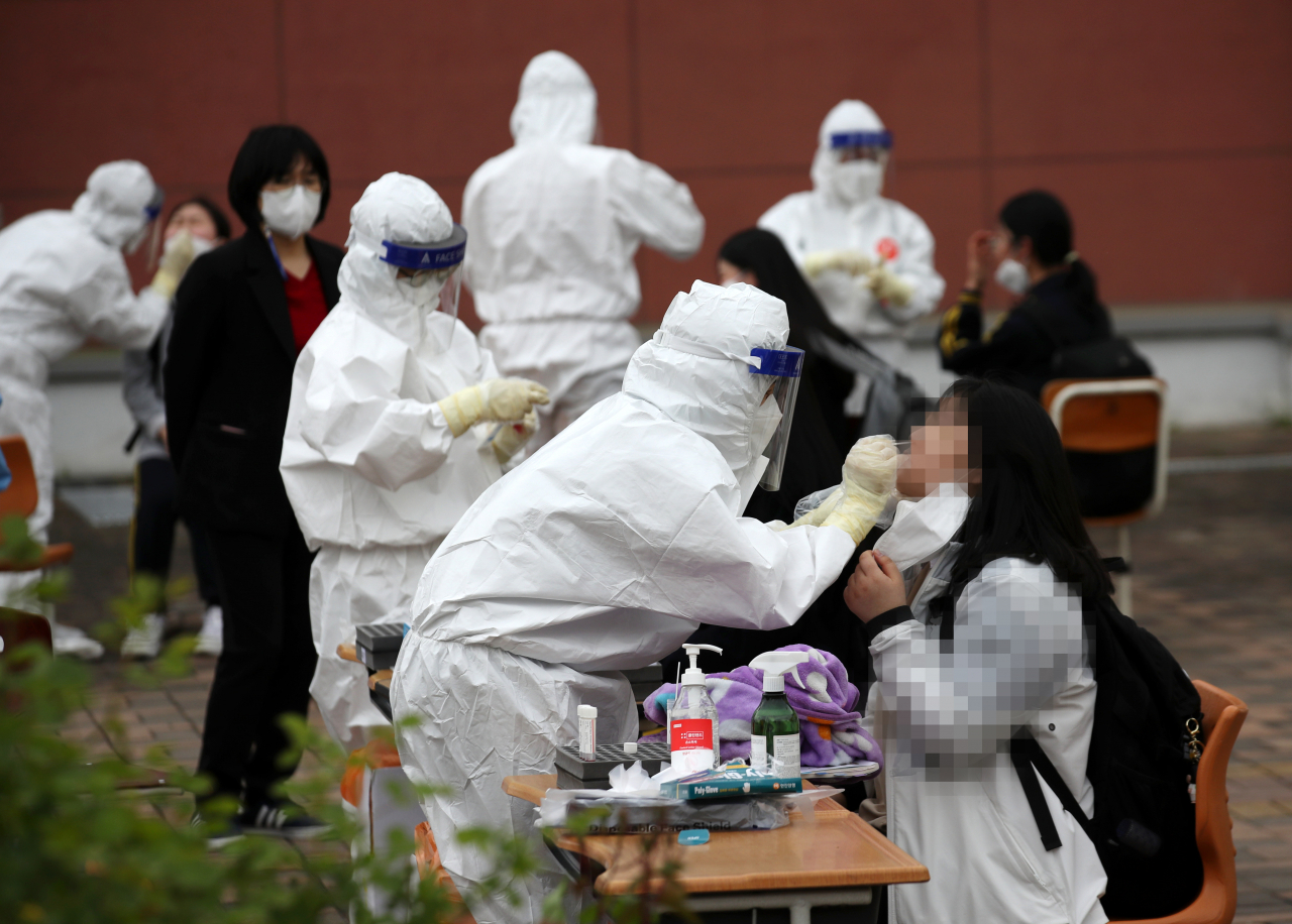 22일 광주 북구 한 고등학교에 마련된 임시선별진료소에서 학생들이 코로나19 검사를 받고 있다. [연합]