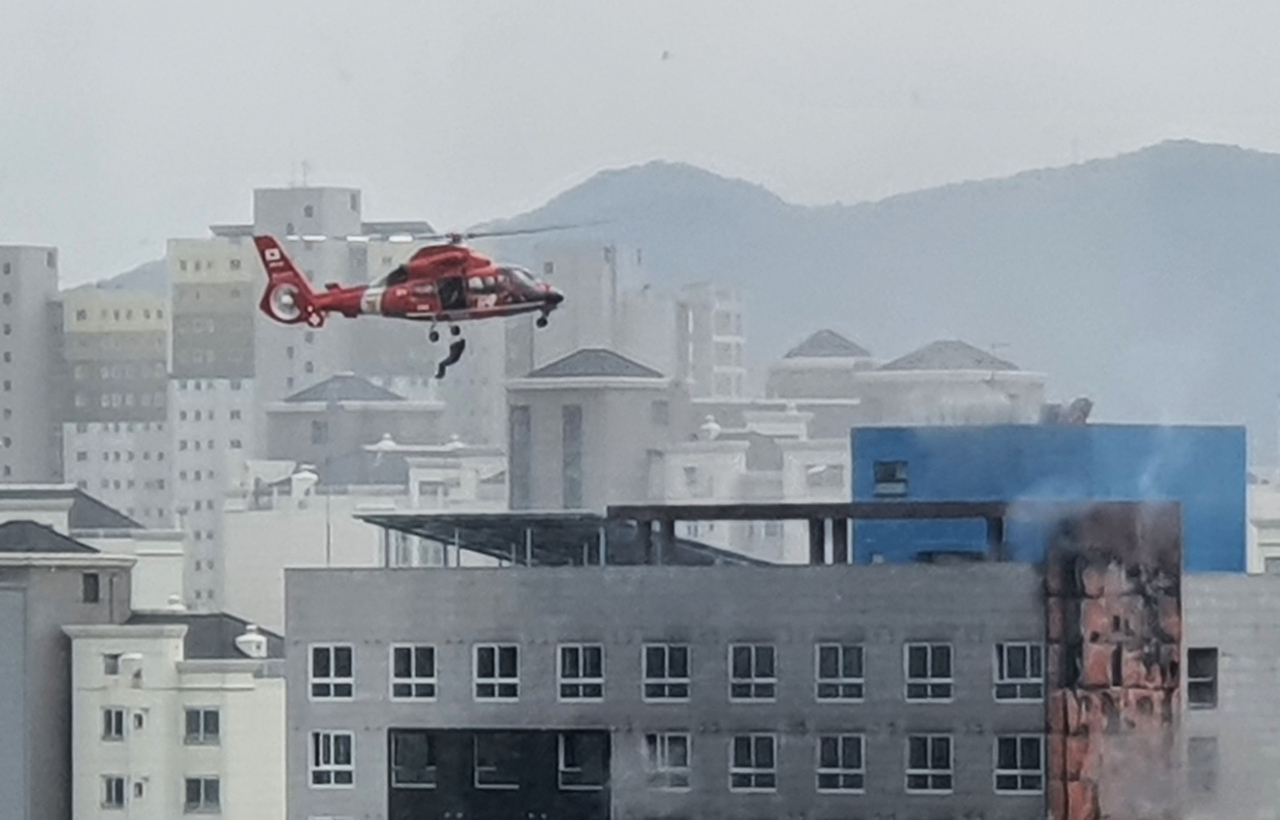 24일 경기 남양주 다산동의 한 오피스텔 신축 공사 현장에서 화재가 발생해 옥상에 대피 중이던 작업자들이 소방 헬기에 의해 구조되고 있다. [연합]
