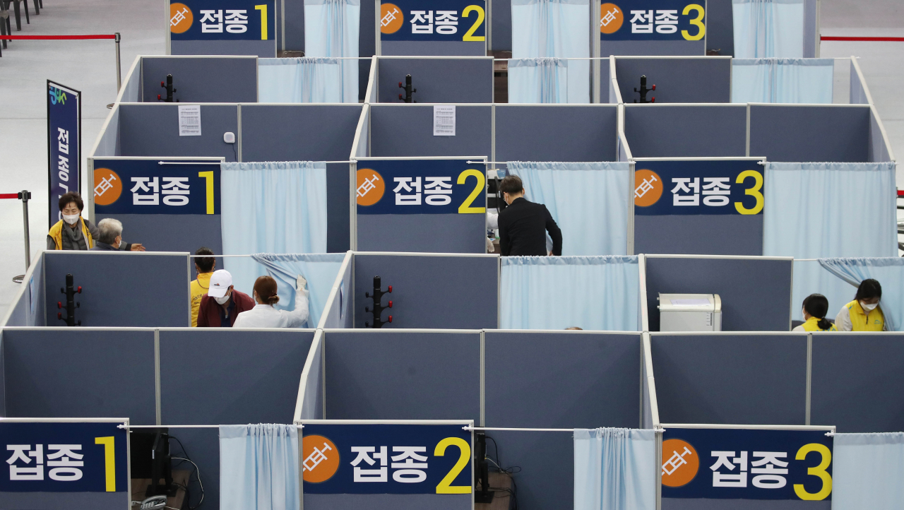 지난 23일 대구 수성구 육상진흥센터에 설치된 수성구 코로나19 예방접종센터에서 시민들이 백신접종을 하고 있다. 수성구 접종센터는 전날부터 75세 이상을 대상으로 화이자 백신접종을 시작했다. [연합]