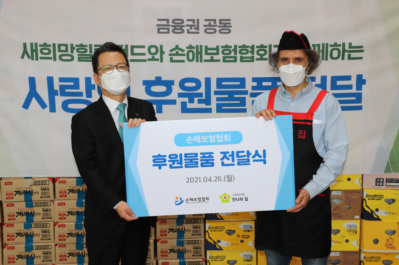 정지원(왼쪽) 손해보험협회 회장이 26일 경기도 성남시 안나의집에서 김하종 신부에게 후원물품을 전달하고 있다. [손해보험협회 제공]