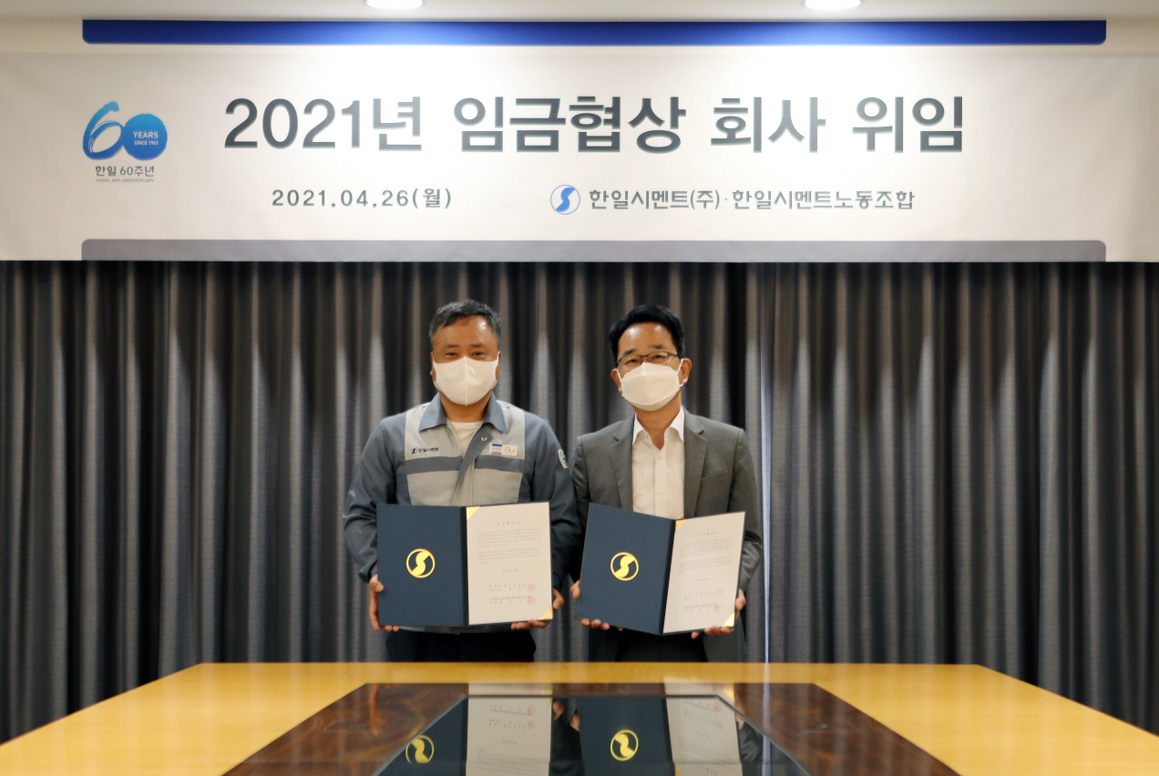 한일시멘트 전근식(오른쪽) 대표와 신광선 노동조합위원장이 올해 임금협상 권한을 회사에 위임하는 합의서를 체결했다. [한일시멘트 제공]