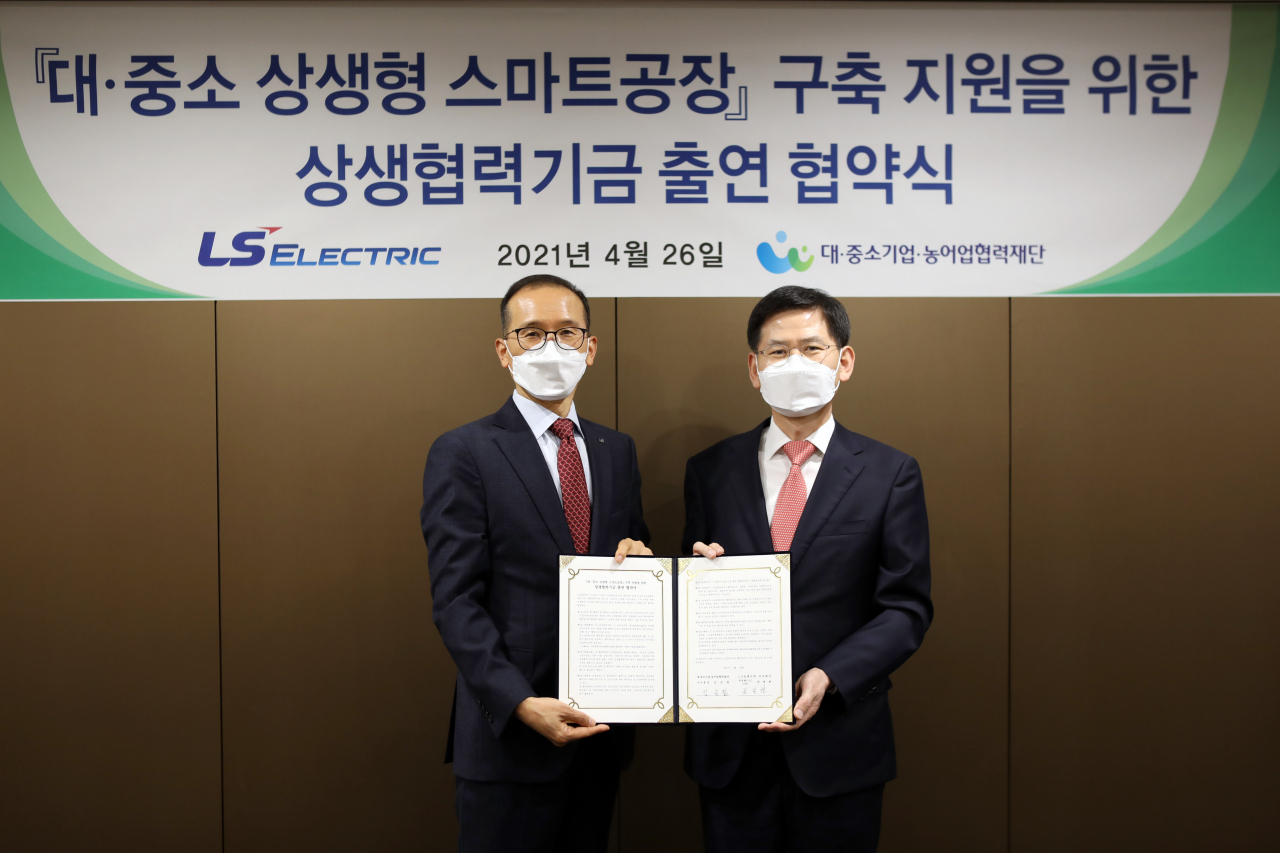 LS일렉트릭은 26일 서울 한강대로 LS타워에서 협약식을 갖고 대·중소기업·농어업협력재단을 통해 상생형 스마트공장 구축 지원을 위한 협력기금 33억원을 출연했다. 사진은 권봉현 LS일렉트릭 자동화CIC COO(왼쪽) 김순철 협력재단 사무총장(오른쪽)이 협약 체결 후 기념촬영을 하고 있는 모습.[LS일렉트릭 제공]