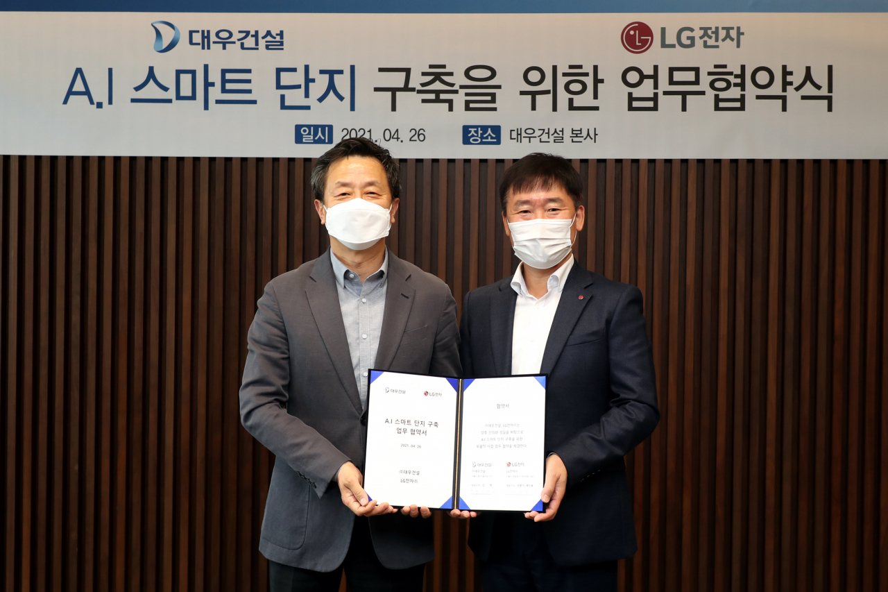 백정완 대우건설 주택건축사업본부장(왼쪽)과 허재철 LG전자 한국B2B그룹장이 지난 26일 서울 을지로 대우건설 본사에서 AI(인공지능) 스마트 단지 구축을 위한 업무협약을 체결한 뒤 기념촬영을 하고 있다. [대우건설 제공]