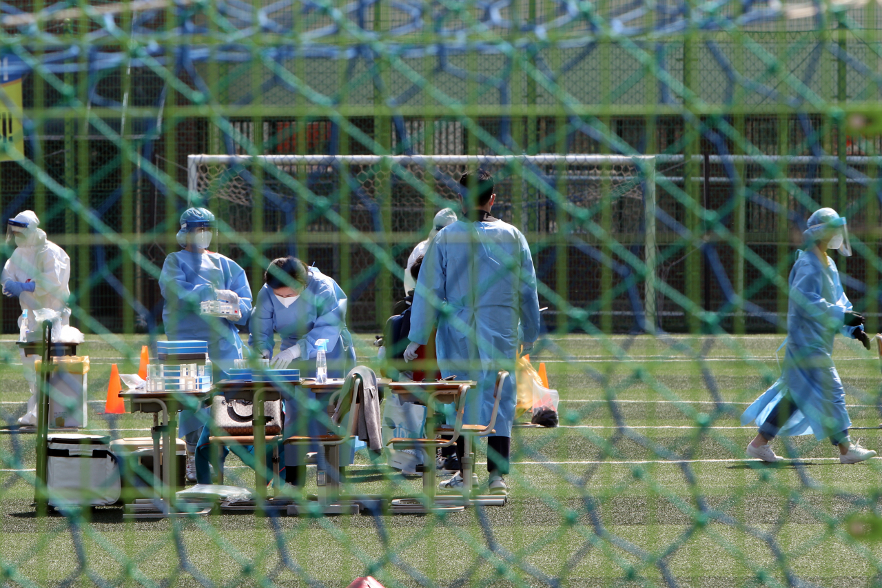지난 19일 오전 광주 광산구 한 초등학교 운동장에 신종 코로나바이러스 감염증(코로나19) 임시 선별진료소가 마련돼 재학생이 전수 검사에 참여하고 있다. 방역 당국은 국회의원 지역 사무소 관계자가 포함된 전남 담양 지인 모임 관련 확산세가 해당 초등학교에까지 미치자 재학생과 교직원을 대상으로 전수 검사에 나섰다. [연합]