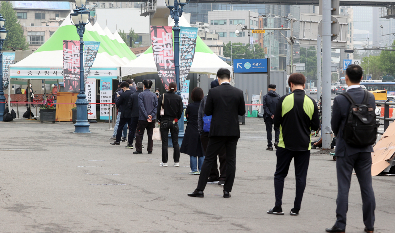 28일 서울역 광장에 설치된 중구 코로나19 임시선별검사소 앞에 검사를 받으려는 시민들이 줄을 서 대기하고 있다. [연합]
