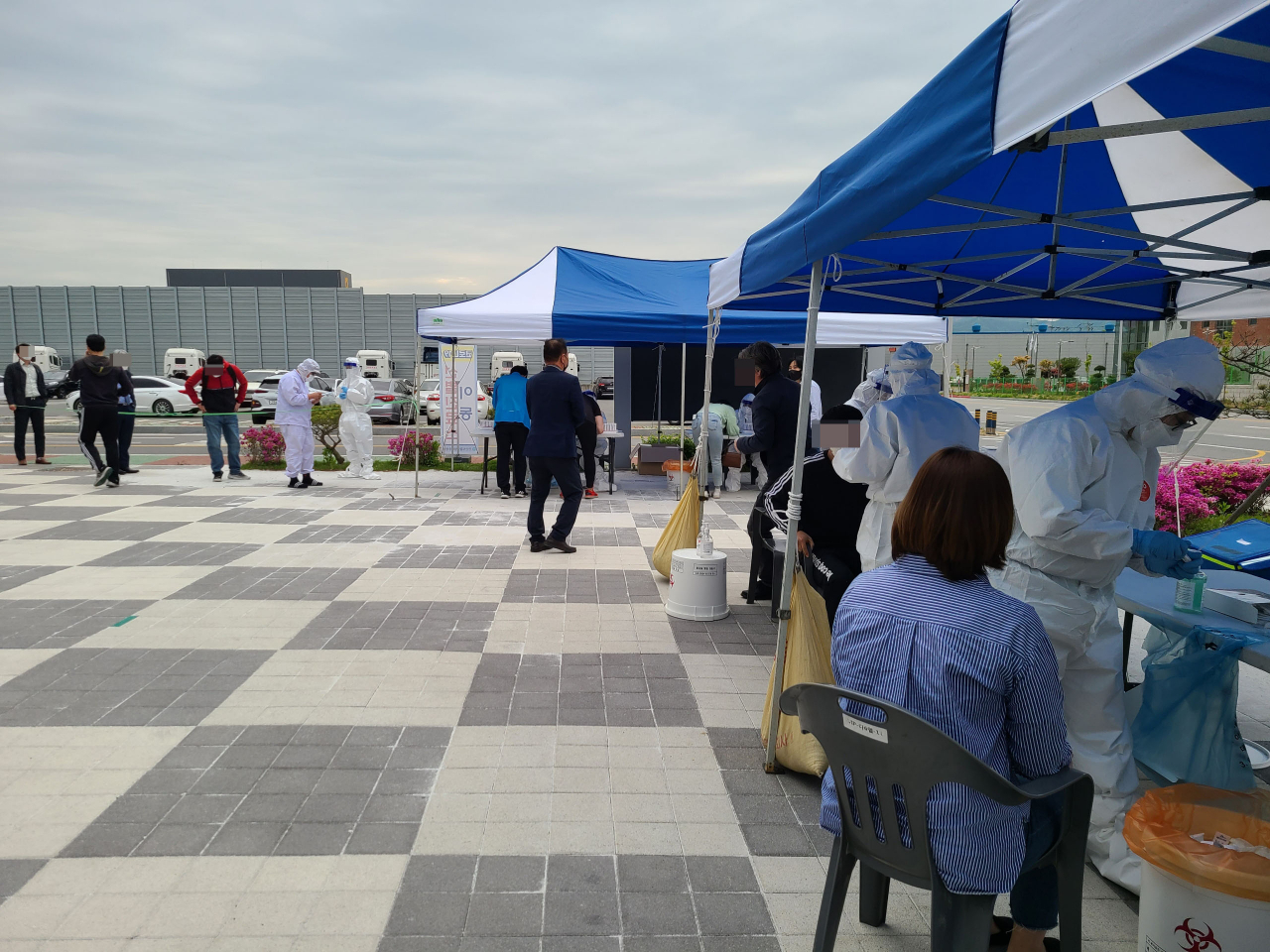 27일 충남 천안 제5산업단지 입주업체 근로자들이 산단 내에 설치된 코로나19 임시 선별진료소에서 검사를 하고 있다.이곳 자동차부품 제조회사인 제원테크에서 이틀동안 27명의 코로나19 확진자가 나오면서 전체 근로자들에 대한 검사가 진행 중이다. [천안시 제공. 재판매 및 DB 금지] [연합]